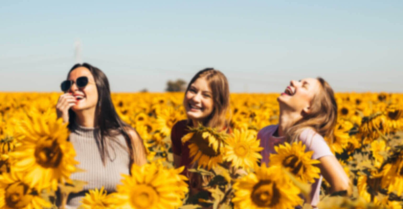 Una pequeña foto borrosa de tres mujeres lijando en un campo de girasoles